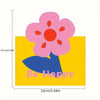 A yellow card featuring a pink flower and the text Be Happy.