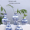 A collection of blue and white porcelain vases featuring intricate floral patterns displayed on a white surface.