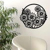 Black metal wall art featuring a silhouette of a dense floral pattern on a white wall.