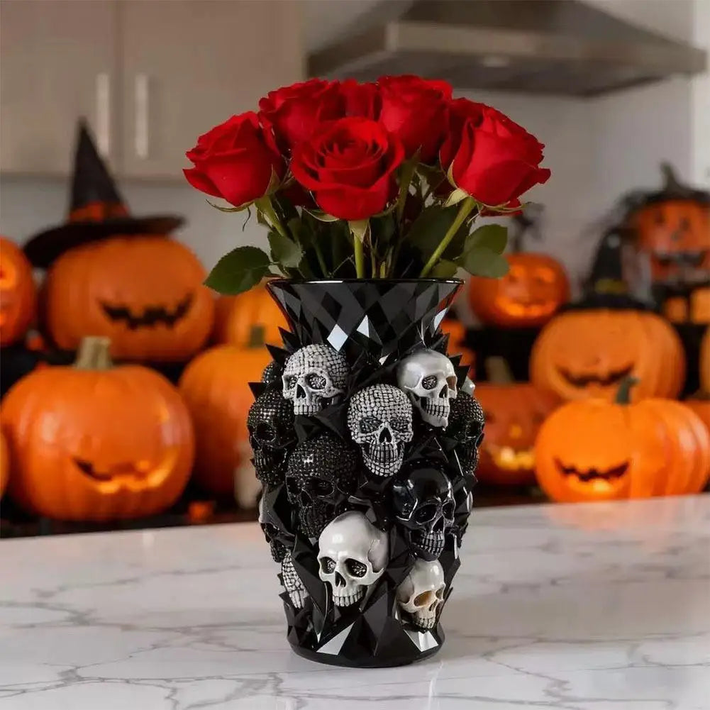 Un vase décoratif noir rempli de roses rouges et de décorations de crânes pour Halloween