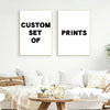 Two framed prints with black text on white backgrounds displayed on a white wall.