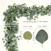 Green artificial eucalyptus garland featuring small white flowers and various leaf shapes.