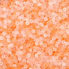 Close-up view of small, translucent orange glass rice beads for jewelry making