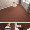 Close-up view of a brown self-adhesive runner rug being applied to a floor.