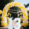 A yellow and white balloon arch decorated with a light-up marquee number sign for 13.