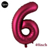 A large, metallic pink foil number balloon shaped like the number 6.