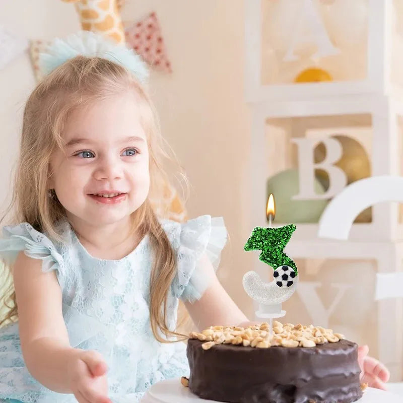 A smiling young girl holds a dark chocolate cake decorated with green soccer-themed candles and a white turkey topper.