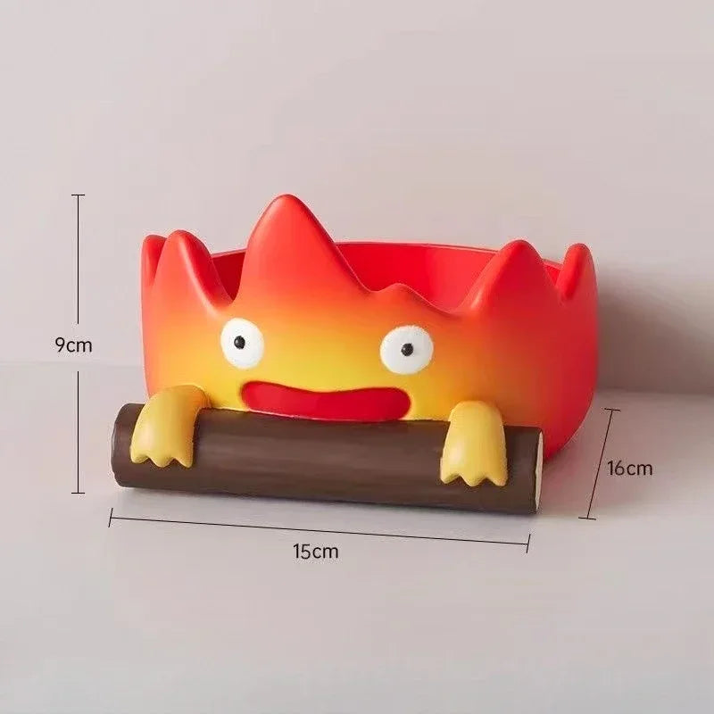 A resin cartoon fire person tray with an orange and red body and yellow features resting on a brown base.