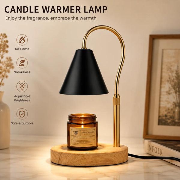 A gold-toned flameless candle warmer lamp with a black shade sits on a wooden base, illuminating a glass jar of aroma serum.