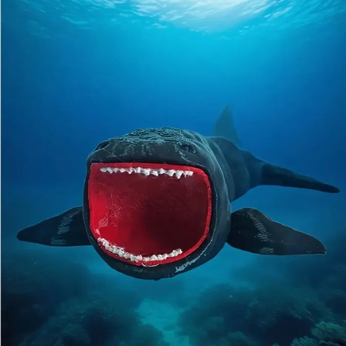 A black sea monster fidget toy with a wide open red mouth is visible underwater.