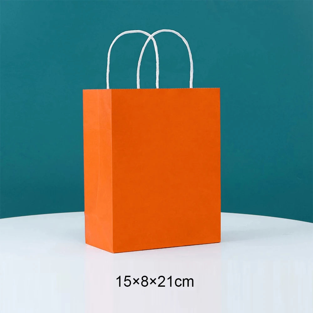 Orange paper gift bag with white handles, measuring 15x8x21 cm.