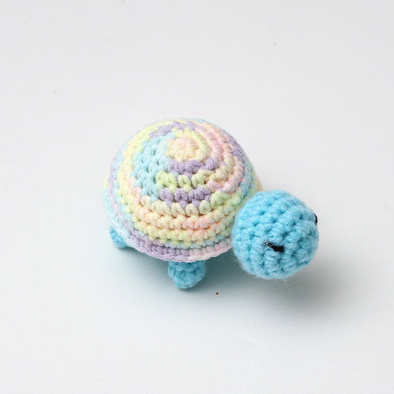 Handmade crocheted turtle plush toy with multicolored body and small dark eyes