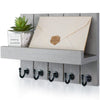 Rustic wooden wall-mounted organizer holding a letter and featuring five black hooks.