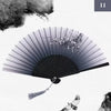 A black vintage silk bamboo folding hand fan is shown open, with delicate white flowers visible near the top.