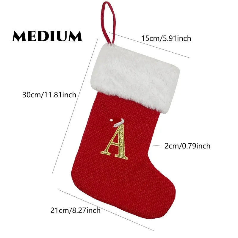 A red knitted sock ornament shaped like the letter A with a white fluffy trim.