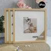 A set of three light wood photo frames with white mats and decorative elements displayed on a beige surface.