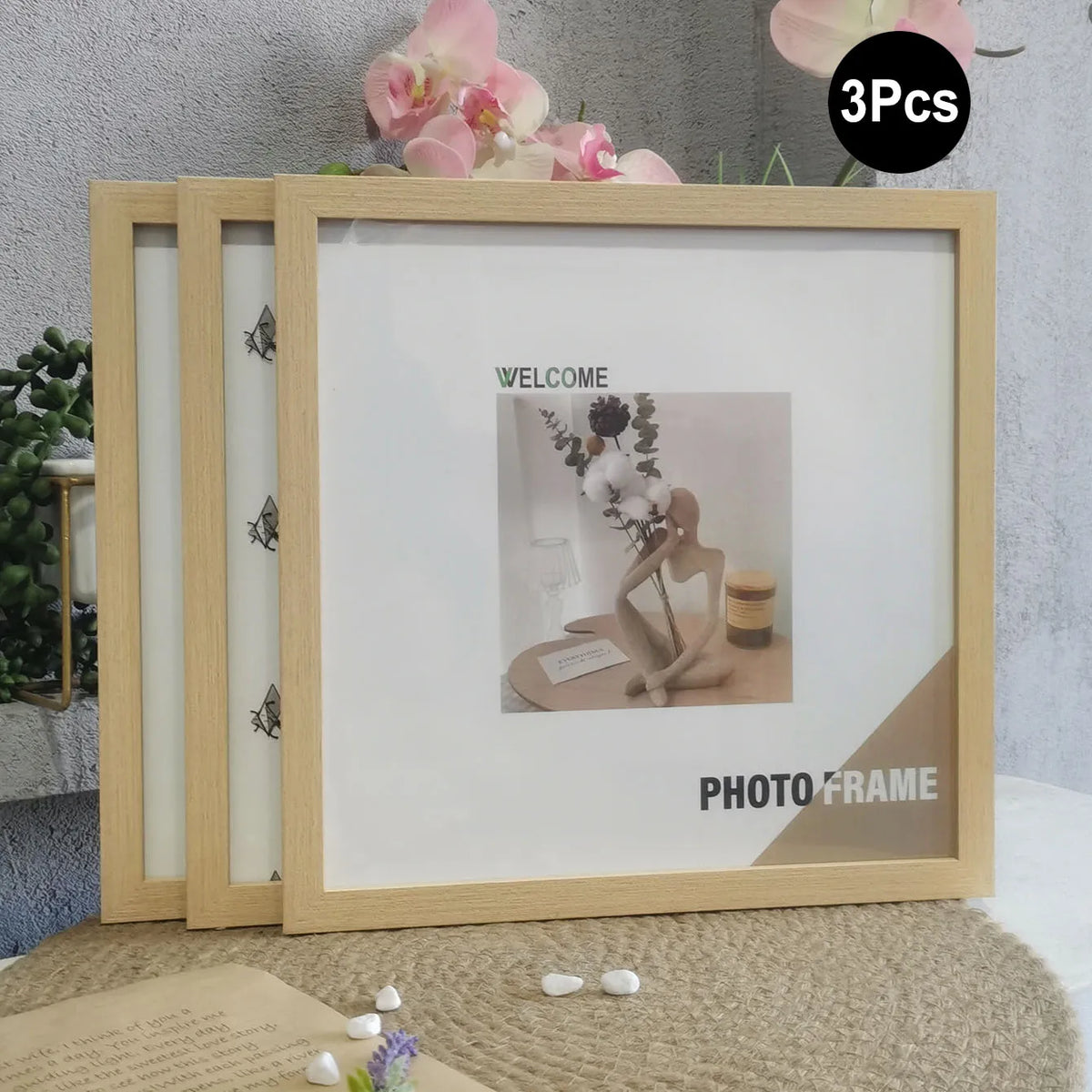 A set of three light wood photo frames with white mats and decorative elements displayed on a beige surface.
