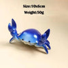 A small, bright blue crab-shaped desk organizer with slots for a pen and phone.