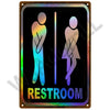 A vintage metal sign with silhouettes of a male and female figure indicating a restroom.