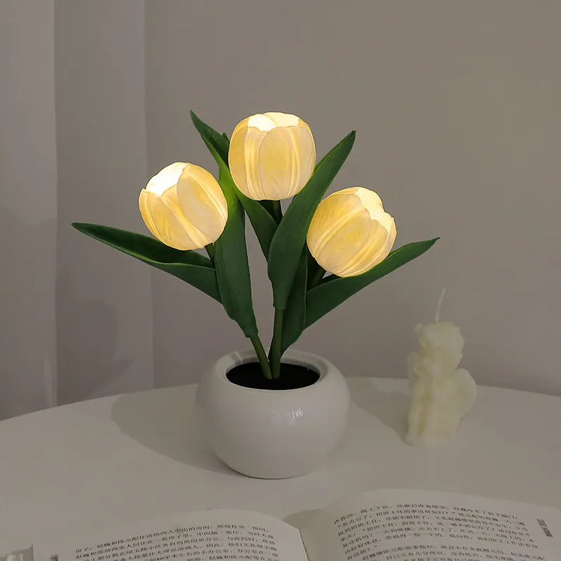 A cluster of glowing yellow LED tulips in a white ceramic pot used as a night light.