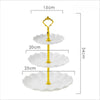 A three-tier gold plastic dessert stand with white scalloped plates.