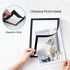 Hands are easily changing a picture in a black magnetic strip photo frame.