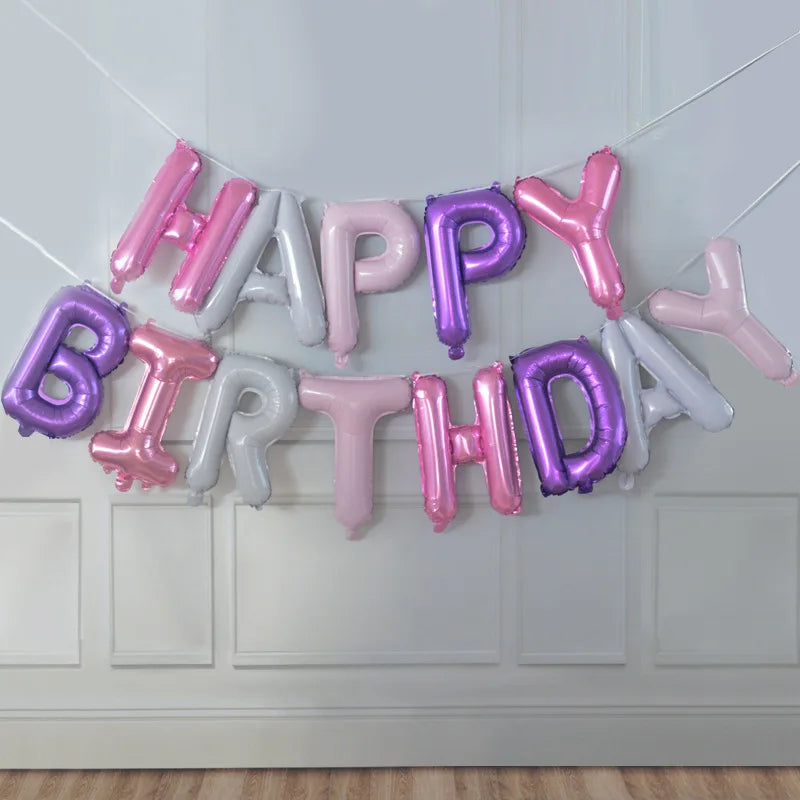 A garland of pink and purple foil letter balloons spelling out Happy Birthday decoration