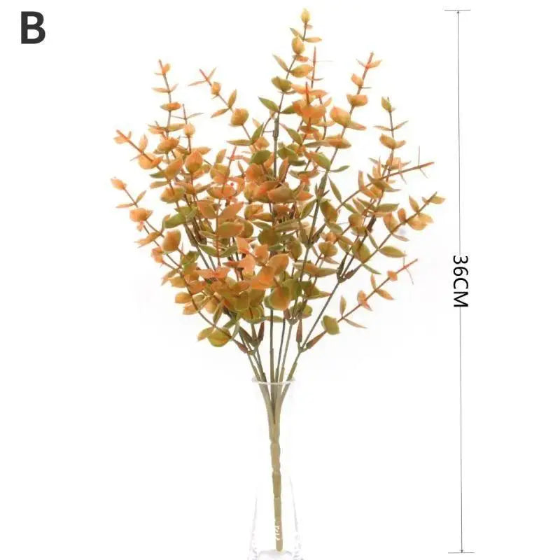 A branch of artificial fall flowers with orange and yellow leaves arranged in a vase.