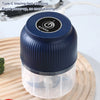 A dark blue portable blender jar with a clear lid sits on a wooden cutting board.