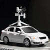 A white armored car model with a turret and antenna mounted on top, photographed against a dark background.