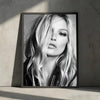 Black and white portrait of a blonde woman with wavy hair looking directly at the camera in a framed print.