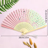 Elegant bamboo folding fan with pink and green floral patterns and a white tassel