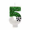 A birthday candle shaped like the number 5 covered in green glitter and featuring a soccer ball design.