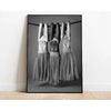Three women with their hands stretched above their heads wearing sheer gray fabric against a dark background.
