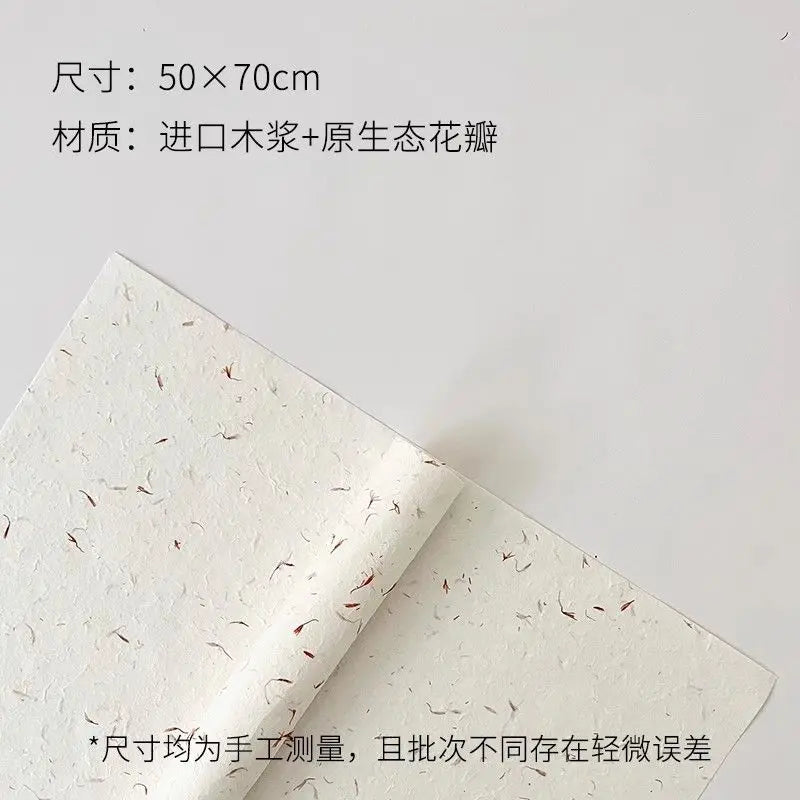 A roll of white decorative packaging paper with dried flower petals rolled up.