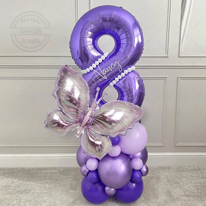 Globo morado número 8 decorado con una mariposa y rodeado de globos morados para fiestas