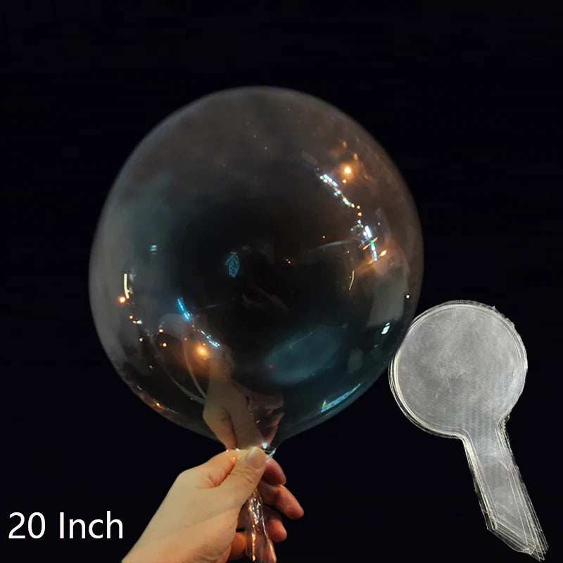 A hand holds a large, transparent inflatable balloon against a dark background.