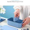 A light blue bento box is shown open on a white table, demonstrating its detachable partition feature.