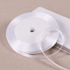 A roll of white satin ribbon on a spool, ready for gift wrapping or DIY crafts.
