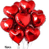 A bunch of shiny red heart-shaped foil balloons tied together on strings.