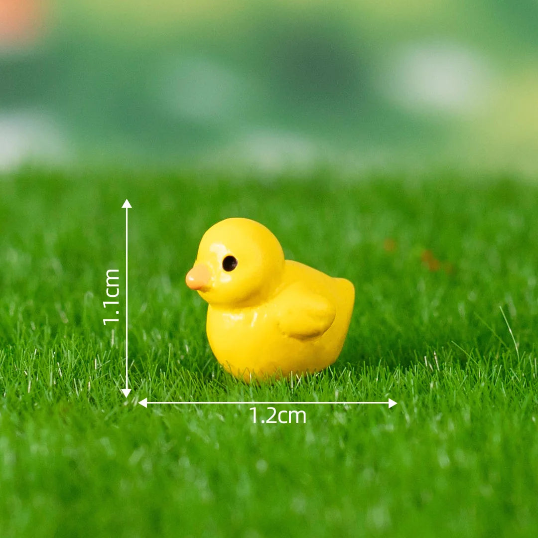 A small yellow duck figurine placed on green grass with measurement lines.