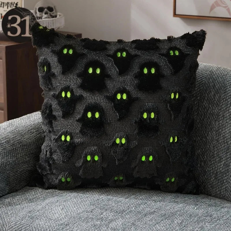 A black plush pillow cover decorated with green pumpkin ghost patterns for Halloween decor