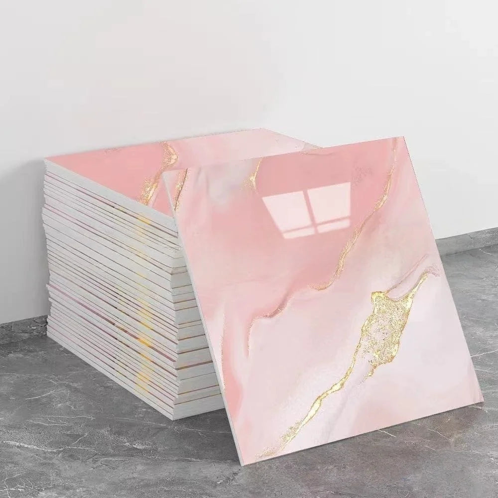 A stack of pink marble tile stickers with gold leaf accents displayed on a gray surface.