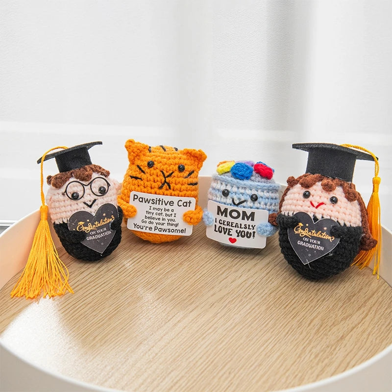 A collection of handmade crochet potato dolls with inspirational slogans and graduation themes.
