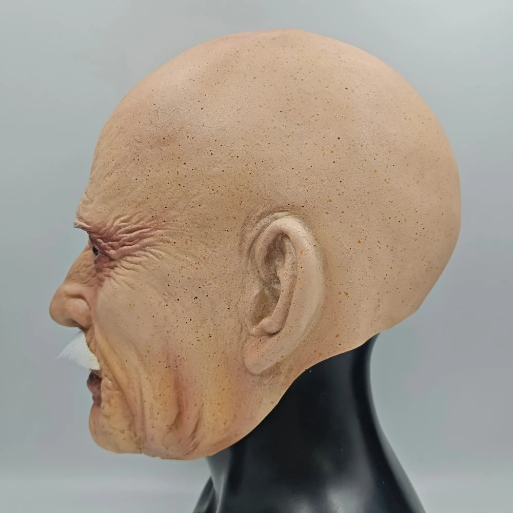 A realistic latex mask of an old man's head, showing wrinkled skin and an open mouth, displayed on a black mannequin.