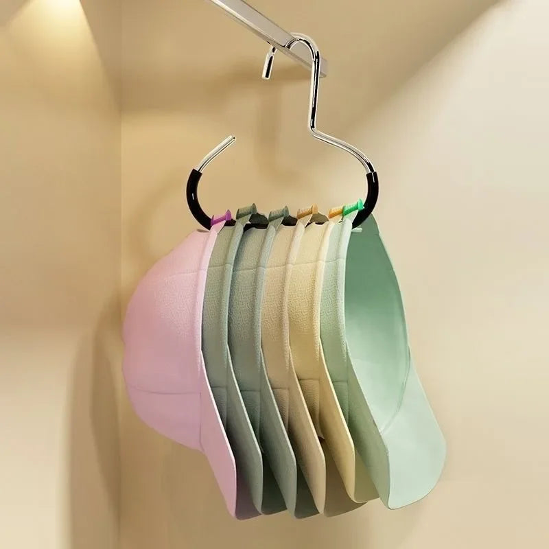 A rack of colorful circle ring hats hanging on a metal hanger against a light beige wall.