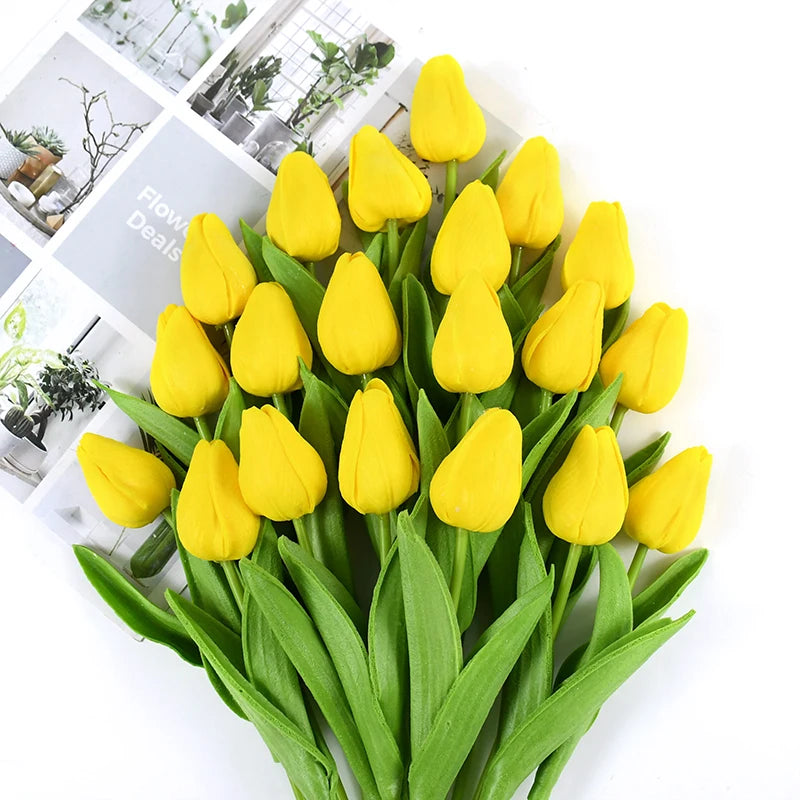 A bouquet of bright yellow artificial tulip flowers with green stems and leaves.