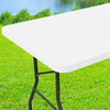 A white stretch tablecloth is displayed on a black metal stand in a grassy outdoor setting.