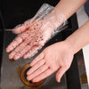 A hand wearing a clear disposable plastic glove with visible red stains is shown over a kitchen sink.