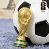 A gold FIFA World Cup trophy is placed on a black and white soccer ball.